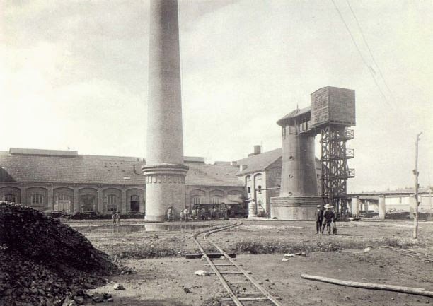Fotografía histórica de una fábrica azucarera con chimenea y edificios auxiliares.