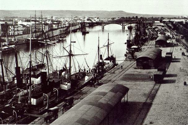 Vista histórica del puerto de Sevilla con embarcaciones atracadas.