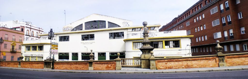 Fotografía panorámica de un edificio de mercado entre inmuebles residenciales.