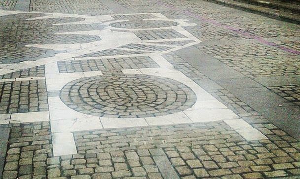 Pavimento de piedra con motivos geométricos circulares.