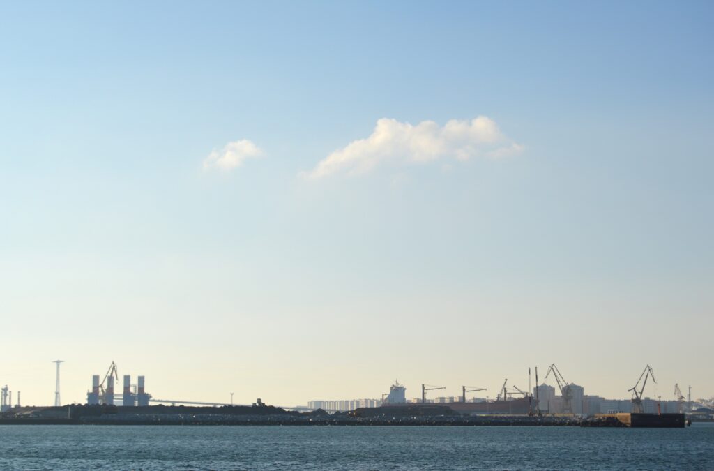 Vista de la bahía desde la orilla, con edificios bajos en el horizonte.