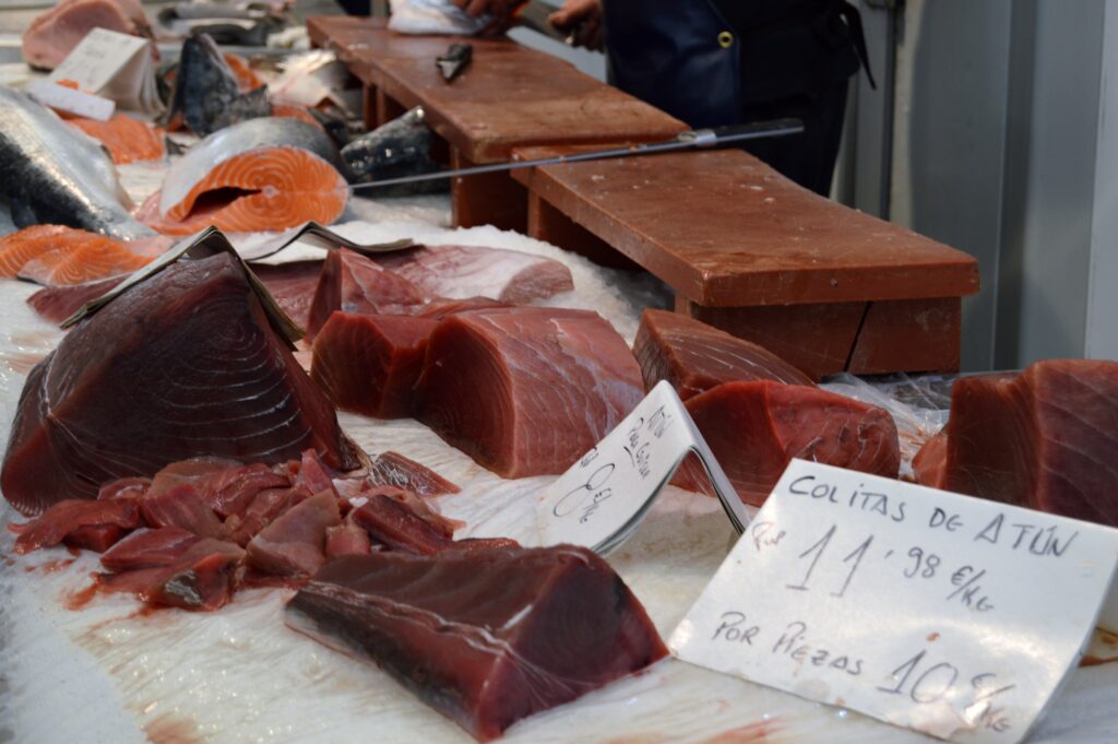 Piezas de pescado rojo expuestas en un puesto de mercado.