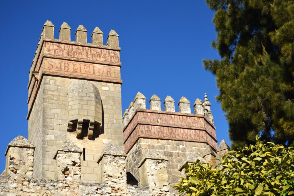Dos torres de piedra con almenas contra un cielo azul.