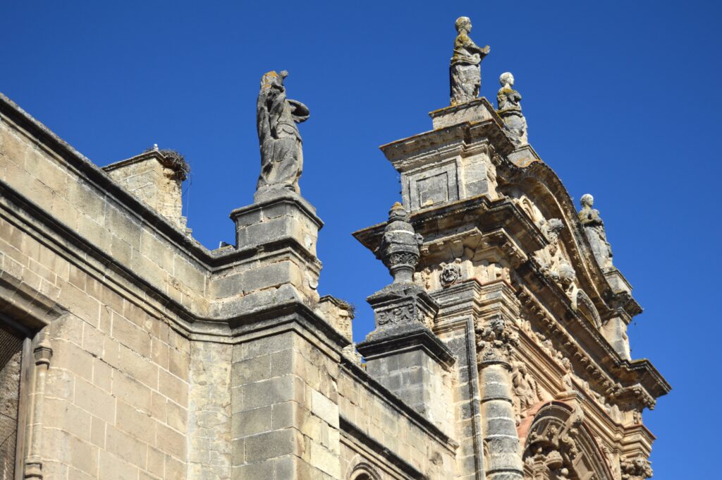 Esculturas y cornisas sobre una fachada histórica.