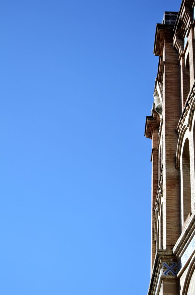 Perfil lateral estrecho de una fachada histórica contra el cielo azul.