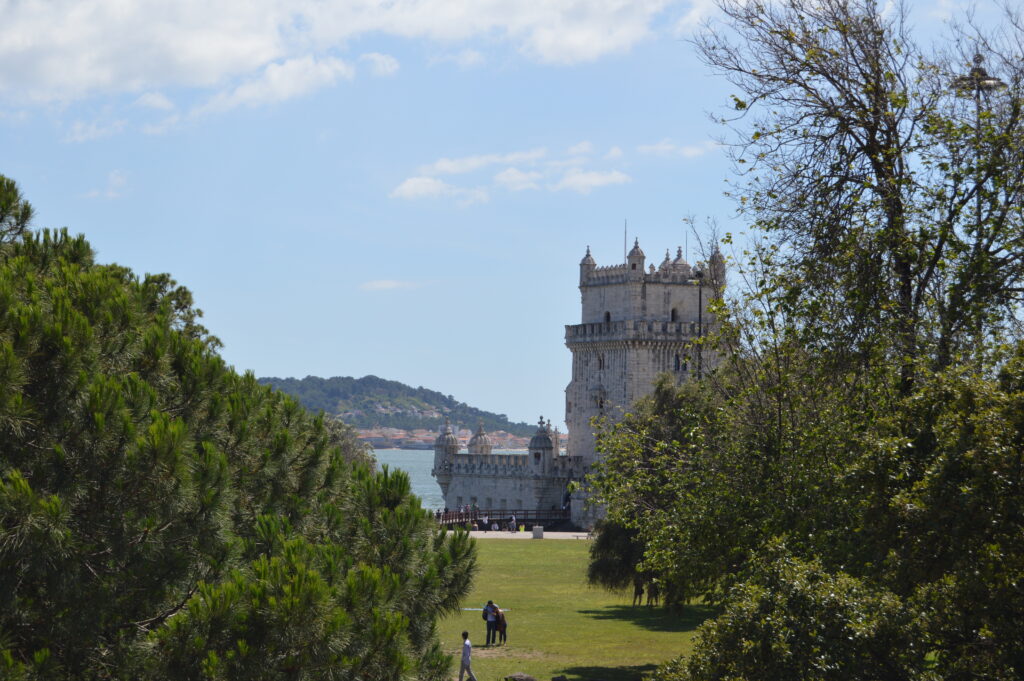 Edificio de piedra al fondo de un jardín arbolado.